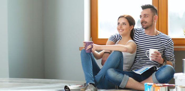 Young couple sitting on floor after moving house
